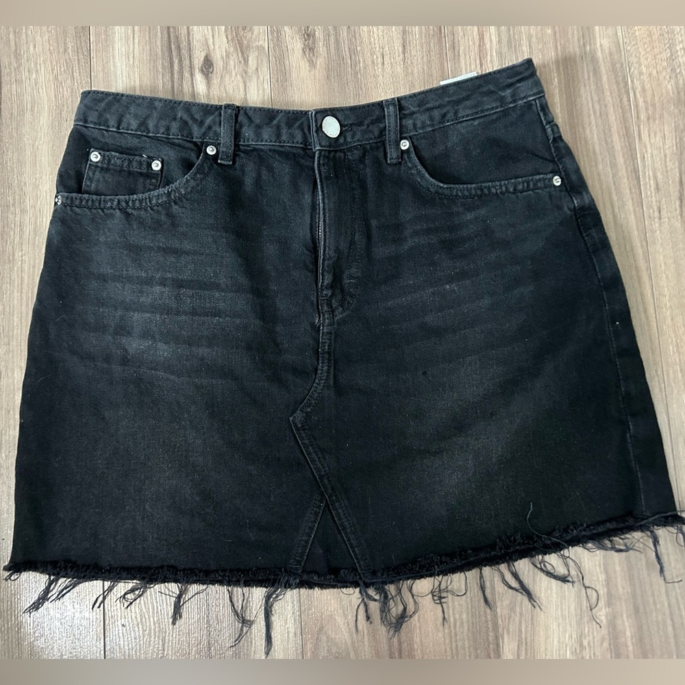 Faded black denim mini skirt with distressed hem